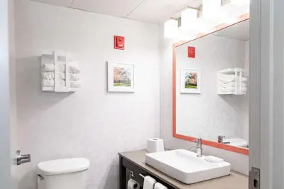 a white bathroom with a sink and a mirror at Hampton Inn & Suites By Hilton- Newark Airport Elizabeth in Newark