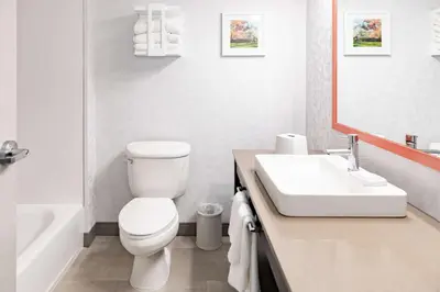 a white bathroom with a toilet and a sink at Hampton Inn & Suites By Hilton- Newark Airport Elizabeth in Newark