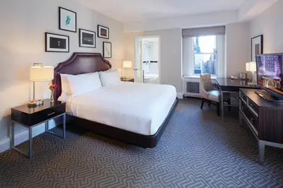 a hotel room with a bed and a desk and a computer at The Lexington Hotel, Autograph Collection in New York