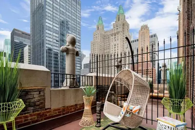 a balcony with a swing and some plants and buildings at The Lexington Hotel, Autograph Collection in New York