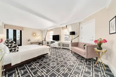 a hotel room with a large bed and a couch at The Lexington Hotel, Autograph Collection in New York