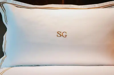 a white pillow with the word ss written on it at Soho Grand Hotel in New York