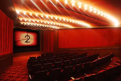 an empty auditorium with red curtains and a stage at Roxy Hotel New York in New York