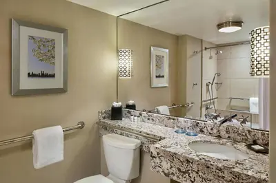 a bathroom with a toilet and a sink and a mirror at Sheraton New York Times Square Hotel in New York