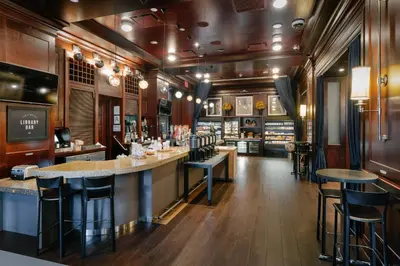 a bar in a restaurant with bar stools at Sheraton New York Times Square Hotel in New York