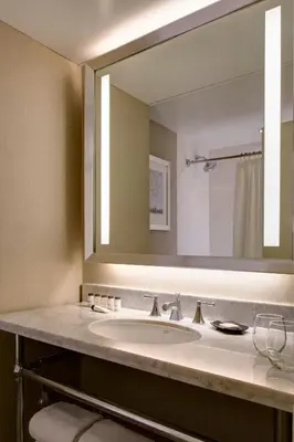 a bathroom with a sink and a large mirror at Sheraton New York Times Square Hotel in New York