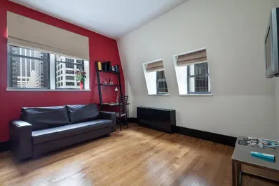 a living room with a couch and a red wall at Eurostars Wall Street in New York