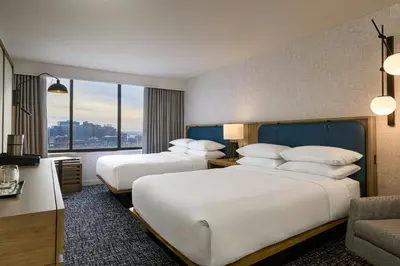 two beds in a hotel room with a large window at Sheraton Philadelphia University City Hotel in Philadelphia