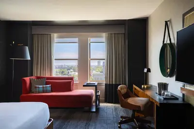 a hotel room with a bed and a red couch at Renaissance Philadelphia Downtown Hotel in Philadelphia