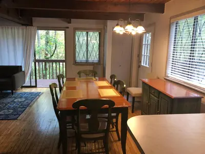 a dining room with a wooden table and chairs at Cozy Cottage at Saw Creek in Bushkill