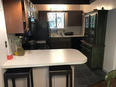 a kitchen with wooden cabinets and a white counter top at Cozy Cottage at Saw Creek in Bushkill