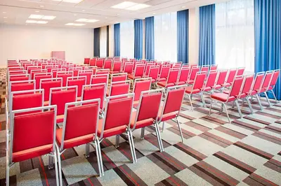 a room full of red chairs in a conference room at Four Points by Sheraton Philadelphia Airport in Philadelphia