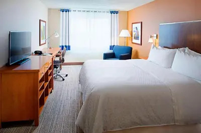 a hotel room with a bed and a desk and a television at Four Points by Sheraton Philadelphia Airport in Philadelphia