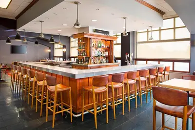 a bar in a restaurant with chairs and tables at Four Points by Sheraton Philadelphia Airport in Philadelphia
