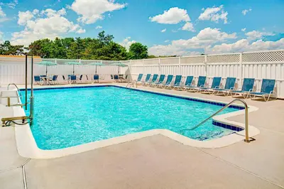 a swimming pool with blue chairs at Four Points by Sheraton Philadelphia Airport in Philadelphia