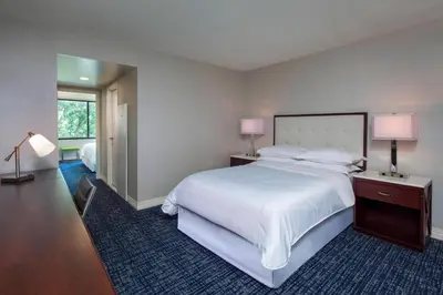 a bedroom with a large white bed and two lamps at Sheraton Suites Philadelphia Airport in Philadelphia