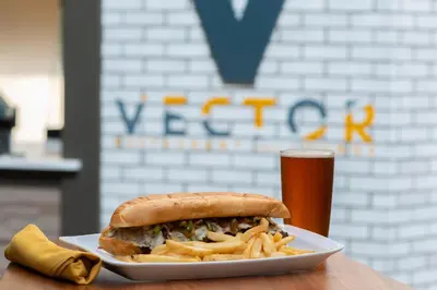 a plate with a sandwich and fries and a glass of beer at Sheraton Suites Philadelphia Airport in Philadelphia