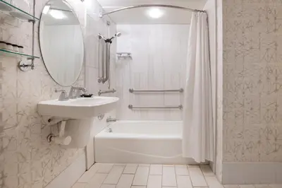 a white bathroom with a sink and a tub and a shower at Sheraton Suites Philadelphia Airport in Philadelphia