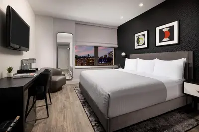 a bedroom with a bed and a desk and a television at Arthouse Hotel in New York