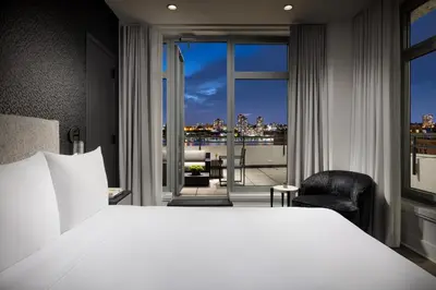 a bedroom with a large white bed and a balcony at Arthouse Hotel in New York