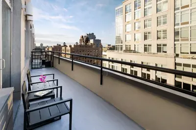 a balcony with two benches and a view of a city at Arthouse Hotel in New York