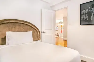 a bedroom with a white bed with a wooden headboard at Paramount Times Square - A Generator Hotel in New York