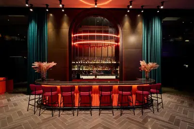 a bar with red chairs and a table with wine glasses at Paramount Times Square - A Generator Hotel in New York