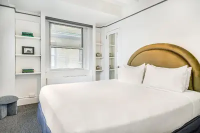 a white bedroom with a large bed and a window at Paramount Times Square - A Generator Hotel in New York