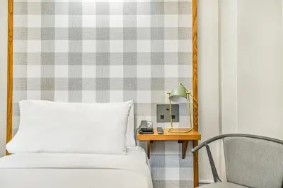 a bedroom with a bed and a table and a chair at Paramount Times Square - A Generator Hotel in New York
