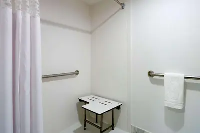 a bathroom with a shower curtain and a table at Hampton Inn Madison Square Garden in New York