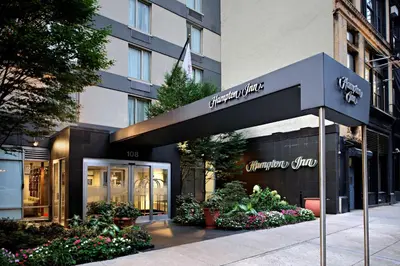 a store with a sign in front of a building at Hampton Inn Manhattan Chelsea in New York