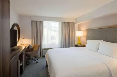 a hotel room with a bed and a desk and a television at Hampton Inn Manhattan Chelsea in New York