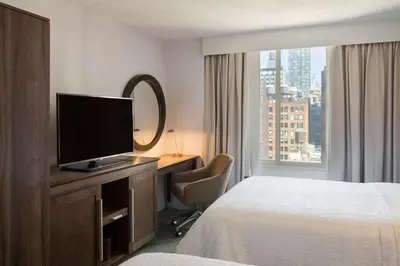 a hotel room with a bed and a flat screen tv at Hampton Inn Manhattan Chelsea in New York