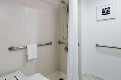 a white bathroom with a shower and a sink at Hampton Inn Manhattan Chelsea in New York