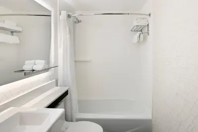 a white bathroom with a toilet and a sink at Holiday Inn Express NYC Chelsea - NoMad Area by IHG in New York