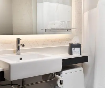 a white bathroom with a sink and a mirror at Holiday Inn Express NYC Chelsea - NoMad Area by IHG in New York