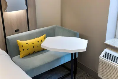 a small white table next to a bed in a room at Holiday Inn Express NYC Chelsea - NoMad Area by IHG in New York