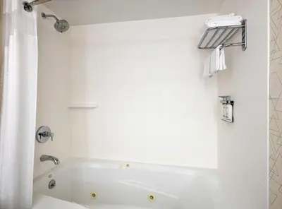 a white bathroom with a tub and a shower at Holiday Inn Express NYC Chelsea - NoMad Area by IHG in New York