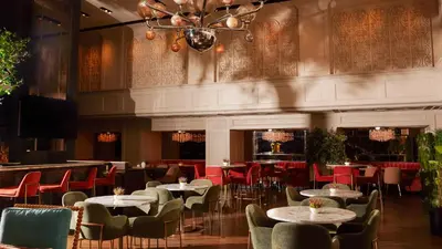 a restaurant with tables and chairs and a chandelier at Park Central Hotel New York in New York