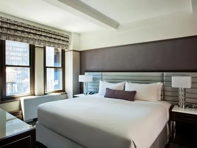 a bedroom with a large white bed and two windows at Park Central Hotel New York in New York