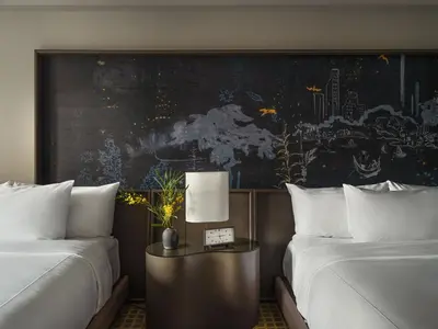 a hotel room with two beds and a table with a lamp at Park Lane New York in New York