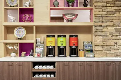 a shelf with a bunch of wine bottles on it at Home2 Suites By Hilton Ridley Park Philadelphia Airport So in Ridley Park