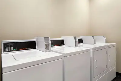a row of white washing machines in a room at Home2 Suites By Hilton Ridley Park Philadelphia Airport So in Ridley Park