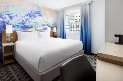 a bedroom with a bed and a desk and a chair at Courtyard New York Downtown Manhattan/Financial District in New York