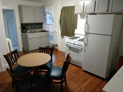 a kitchen with a white refrigerator and a table and chairs at Hotel Wayne in Honesdale