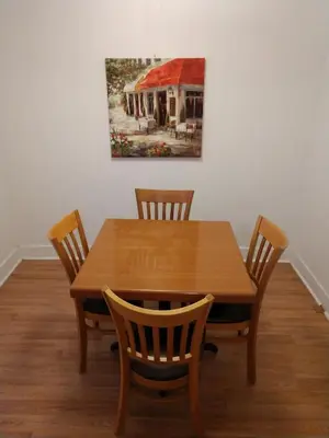 a wooden table with four chairs and a painting on the wall at Hotel Wayne in Honesdale