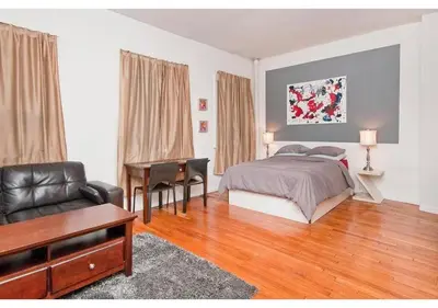 a bedroom with a bed and a desk and a piano at great studio apt new york city in New York