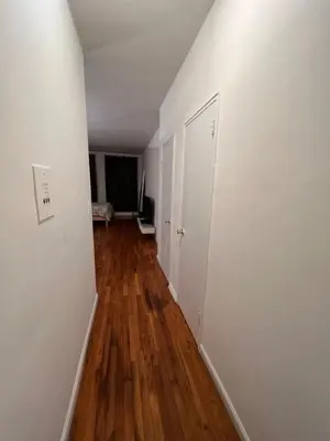 an empty hallway with white walls and wood floors at great studio apt new york city in New York