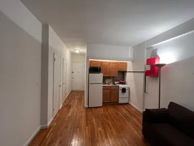 a kitchen with a white refrigerator and wooden floors at great studio apt new york city in New York