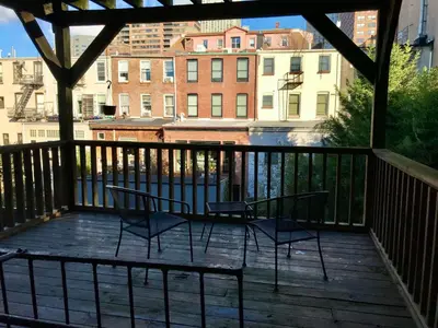 two chairs and a table on a balcony with buildings at Historic 1869 Brownstone 15 min to NYC downtown in Jersey City